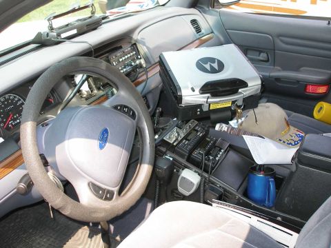 1998 Ford Crown Victoria - The interior of a 1998 Ford Crown Victoria police car is equipped with multiple radios and a laptop.