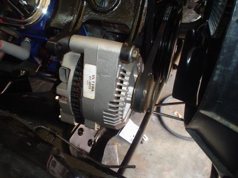 1984 Ford Bronco - New alternator with an 'ULTIMA 01-0203' parts label mounted on its bracket at the front of an engine, with the serpentine/V-belt wrapped ar…