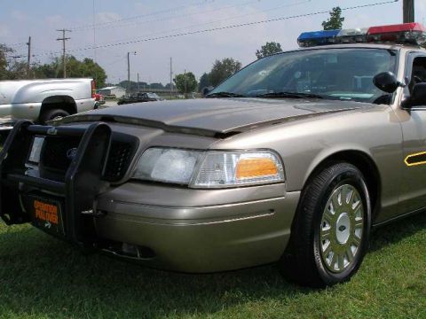 1998 Ford Crown Victoria - This 1998 Ford Crown Victoria police car features a push bar and light bar, seen at a car show.