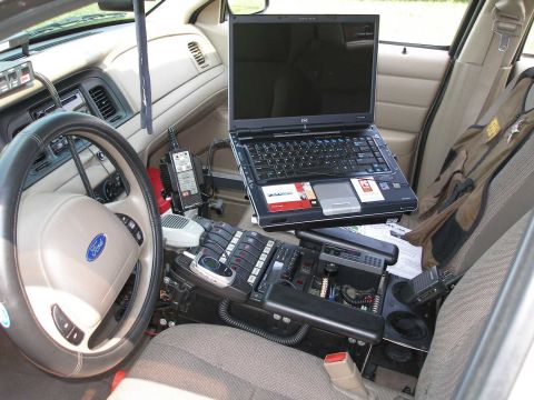 1998 Ford Crown Victoria - Interior view of a 1998 Ford Crown Victoria police car, equipped with a laptop and communication devices.
