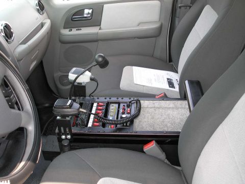 1998 Ford Crown Victoria - The interior of a police vehicle is shown, focusing on the center console with communication and control equipment.