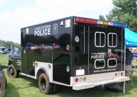 1998 Ford Crown Victoria - A custom-built police truck with 'Special Response Team' markings is parked on grass at an outdoor event.