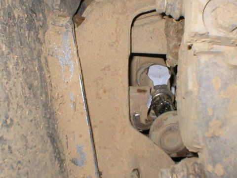 1978 Ford Bronco - A close-up view of a vehicle's undercarriage reveals mechanical components covered in dirt and grime.