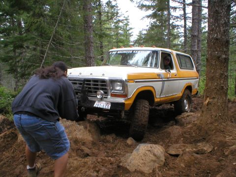 1978 Ford Bronco - 1978 Ford Bronco tackling a challenging off-road course in a forest setting.