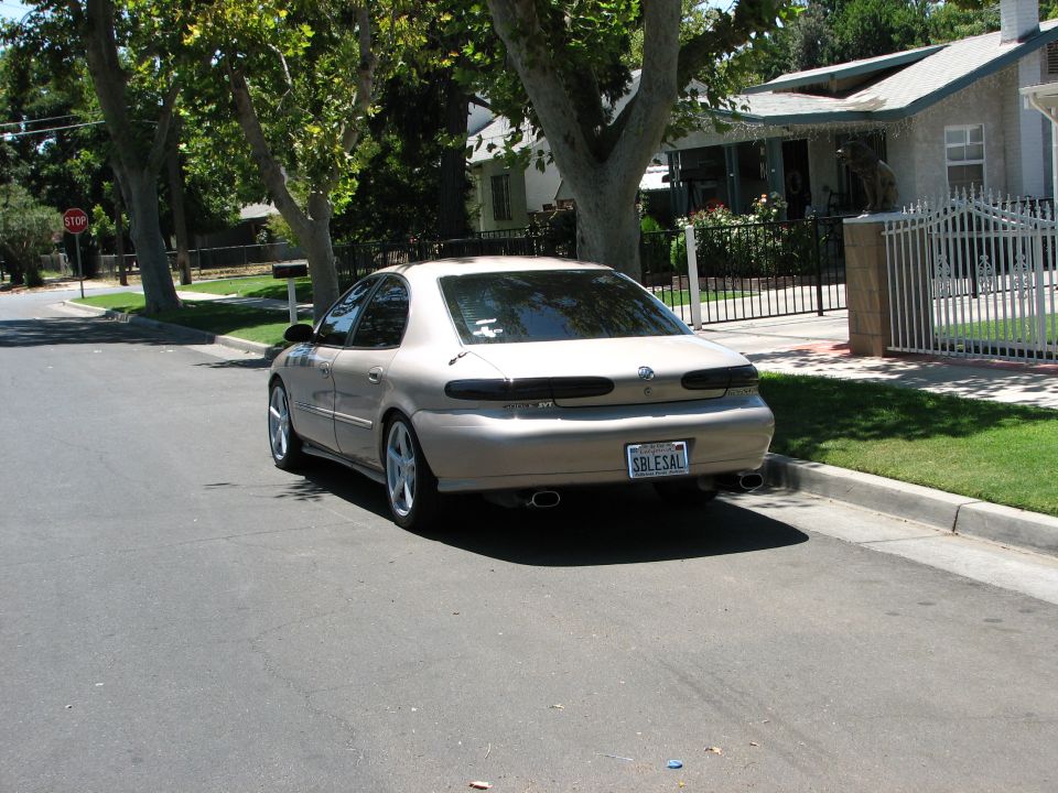 tan 1998 Mercury Sable parked on residential street, rear view