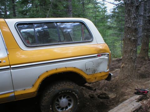 1978 Ford Bronco - A yellow and white 1978 Ford Bronco is seen from the rear quarter panel, parked off-road.