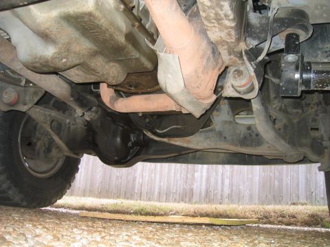 1996 Ford Bronco - Underbody view of a lifted 4x4 shot from beside the front tire, showing the black cast differential housing and independent front beam axle…