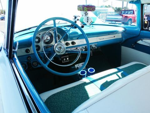 2001 Mercury Grand Marquis - The interior of a classic 1956 Ford Fairlane features a distinctive blue dashboard and steering wheel, adorned with novelty dice.
