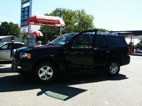 2001 Mercury Grand Marquis - A black Ford Expedition is parked at a car wash with its doors open, under a sunny sky.