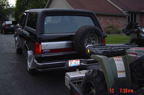 1991 Ford Bronco - The rear of a black Ford Bronco is visible, with a spare tire mounted externally.