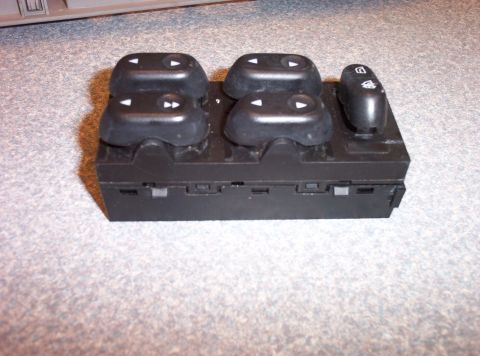 1998 Ford Crown Victoria - A black power window switch assembly with four window control buttons and one lock button is shown.