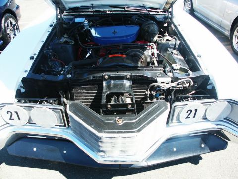 2001 Mercury Grand Marquis - The engine compartment of a vintage automobile is displayed with its hood open, revealing the engine and front grille.