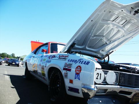 2001 Mercury Grand Marquis - A vintage race car with its hood open, displaying numerous sponsor decals and the number 21.