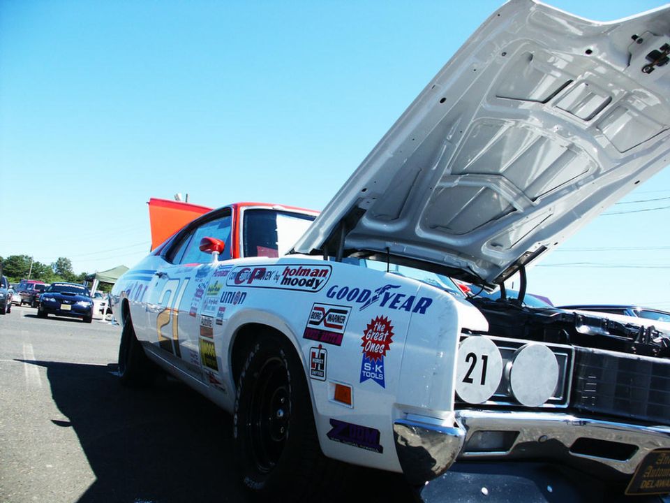 White race car with hood open, number 21, Goodyear decals, and various sponsor stickers