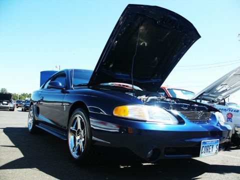2001 Mercury Grand Marquis - A blue coupe with its hood open at a car show, displaying custom wheels and a personalized license plate.