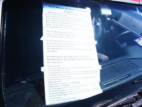 2001 Mercury Grand Marquis - A document on the windshield provides historical details about a replica race car, including its restoration timeline.