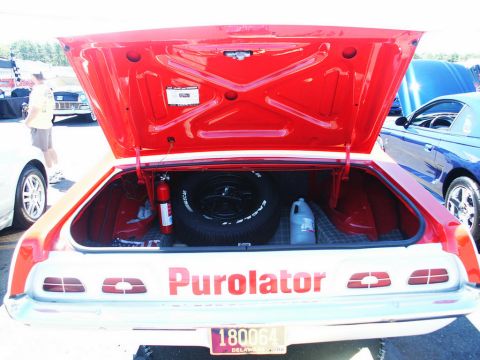 2001 Mercury Grand Marquis - The open trunk reveals a spare tire, fire extinguisher, and "Purolator" branding on the rear of the vehicle.