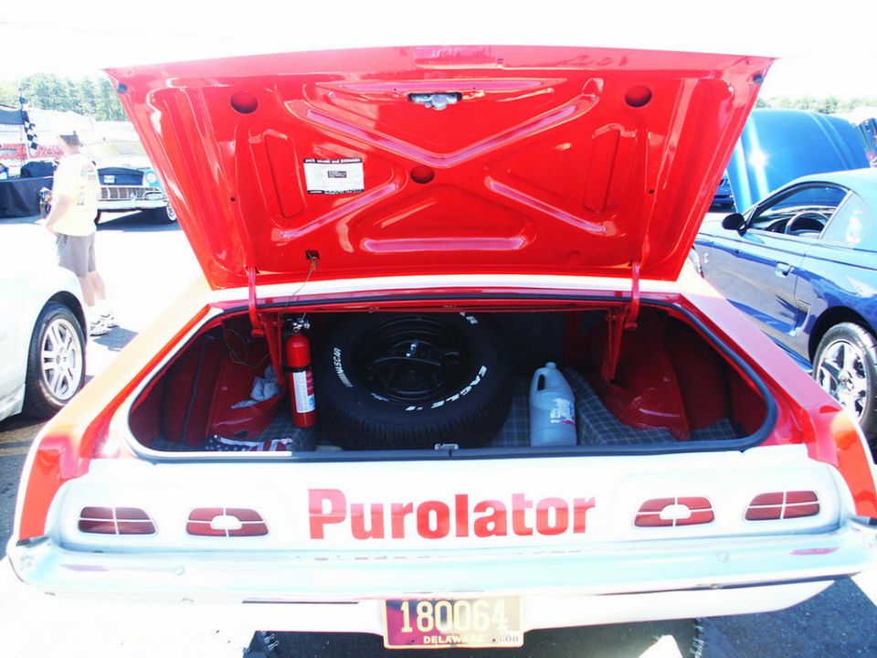 Trunk interior with spare tire, fire extinguisher, and "Purolator" text on the rear