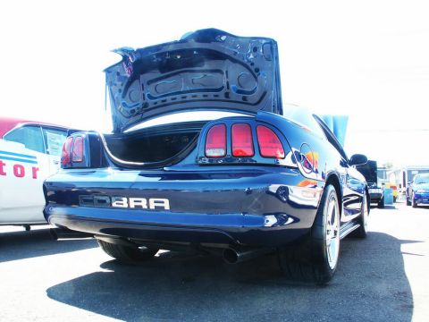 2001 Mercury Grand Marquis - A blue Ford Mustang Cobra is parked with its trunk open, revealing the car's interior.
