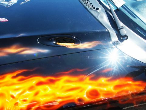 2001 Mercury Grand Marquis - A car hood displays custom flame graphics and a bright sun glare.