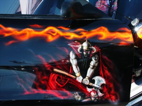 2001 Mercury Grand Marquis - This car door features a detailed airbrush design of a warrior wielding an axe amidst flames and skulls.
