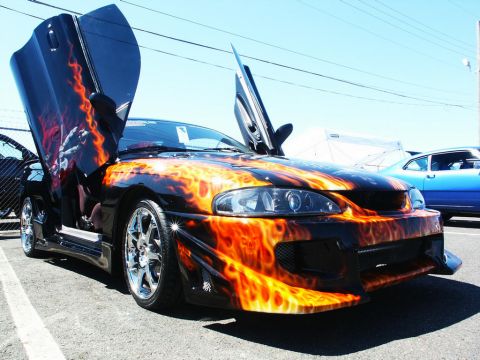 2001 Mercury Grand Marquis - Custom sports car with flame paint and gullwing doors at a car show.