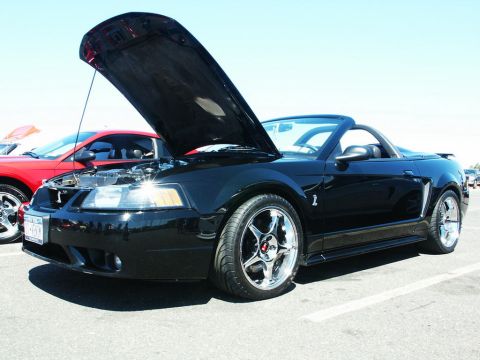 2001 Mercury Grand Marquis - Black convertible sports car at a car show with hood open, another car visible behind.