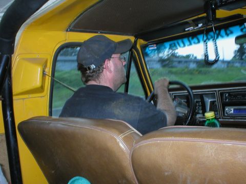 1978 Ford Bronco - Interior view of a yellow vehicle with a man driving, seen from the back seat.