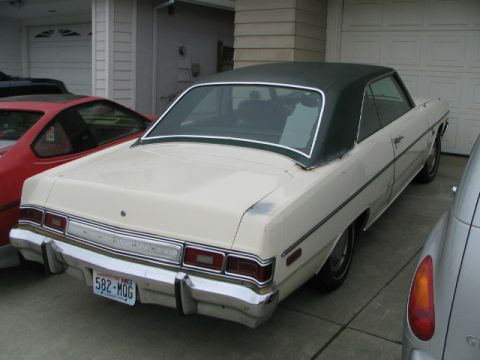 1975 Dodge Dart - This 1975 Dodge Dart features a two-tone paint scheme with a cream body and a dark green vinyl roof, seen from the rear.