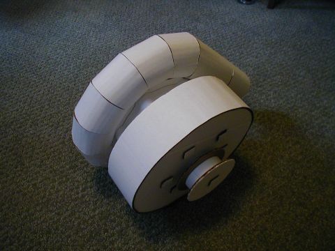 1993 Ford Probe - A homemade cardboard model of a supercharger sits on a carpeted floor.