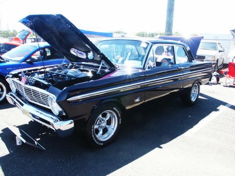 2001 Mercury Grand Marquis - A black 1963 Ford Falcon is displayed with its hood open, revealing the engine bay. The car features chrome accents and custom wheels.