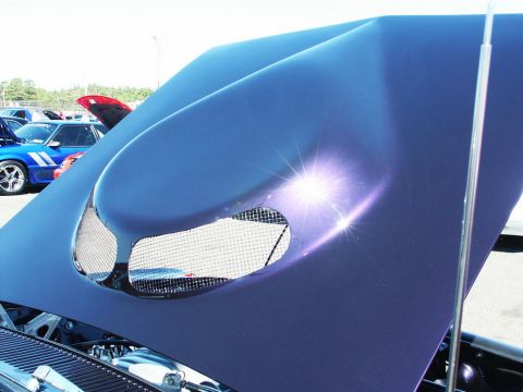2001 Mercury Grand Marquis - A custom hood scoop with mesh detailing is shown, with other vehicles in the background at an outdoor event.