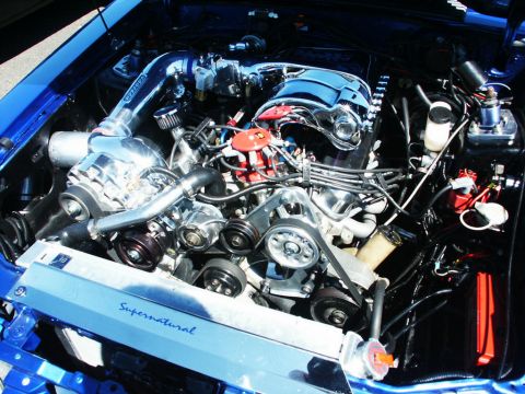 2001 Mercury Grand Marquis - Close-up of a highly modified V8 engine, a prominent supercharger and custom cooling system components.