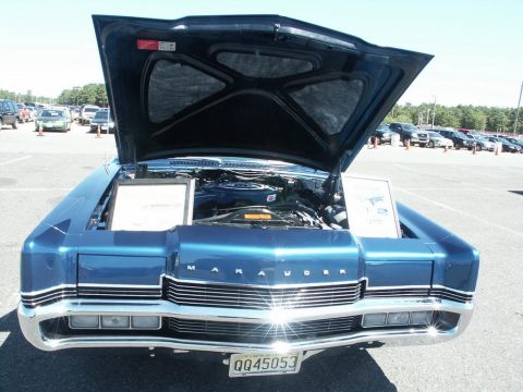 2001 Mercury Grand Marquis - A blue car with its hood open is displayed at an outdoor event with other vehicles in the background.