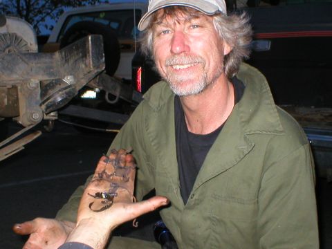 1978 Ford Bronco - A man displays a scorpion he found on his hand, with parts of a vehicle visible in the background.