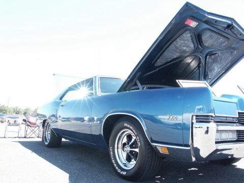 2001 Mercury Grand Marquis - Blue classic car with hood open, parked outdoors at a car show.