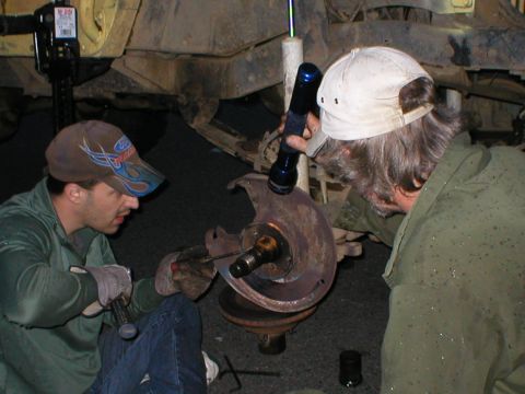 1978 Ford Bronco - Two mechanics examine a vehicle's brake rotor and hub assembly.