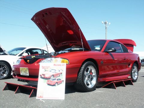 2001 Mercury Grand Marquis - Red 1994 Ford Mustang GT on display at a car show, with a sign and another car visible.