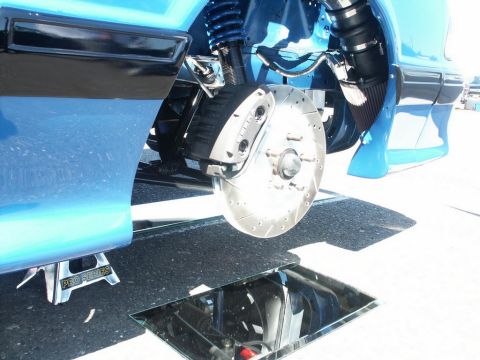 2001 Mercury Grand Marquis - Custom brake system on a blue vehicle, a drilled and slotted rotor and a large caliper, with a jack stand visible.