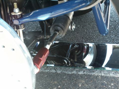 2001 Mercury Grand Marquis - A close-up view of the steering and suspension system of a vehicle, showing various metal components and a rubber boot.