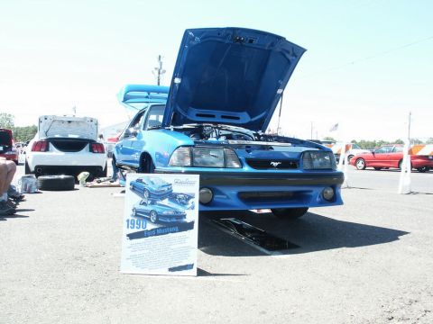 2001 Mercury Grand Marquis - Blue 1990 Ford Mustang displayed at a car show with its hood open.