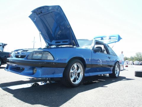 2001 Mercury Grand Marquis - A blue coupe with its hood and trunk open sits on display at an outdoor event.