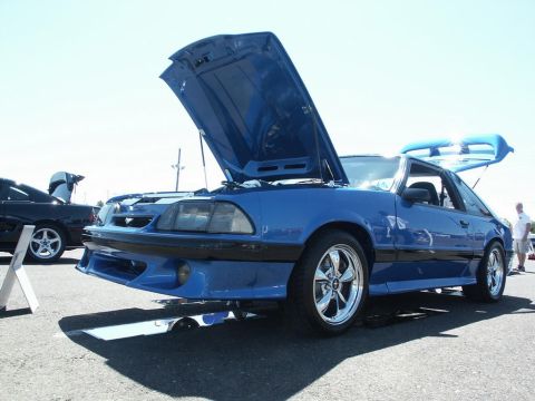 2001 Mercury Grand Marquis - A blue coupe with its hood and trunk open sits at a car show next to another vehicle.