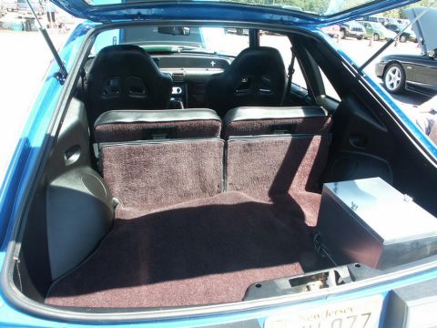 2001 Mercury Grand Marquis - Interior view of a blue hatchback showing racing seats and cargo area, with other vehicles in the background.