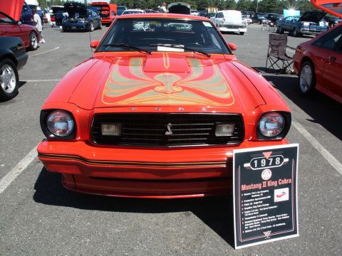 2001 Mercury Grand Marquis - A red 1978 Ford Mustang II King Cobra is displayed at a car show, a distinctive hood graphic and a Cobra emblem on the grille.