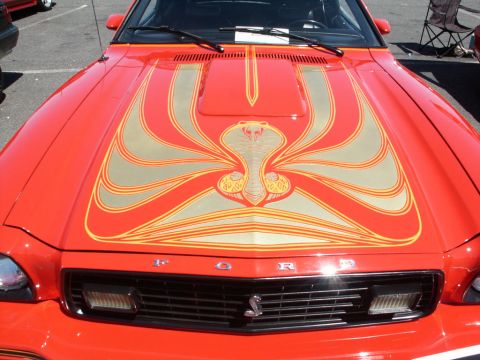 2001 Mercury Grand Marquis - Front view of a red car with a distinctive cobra graphic on its hood.