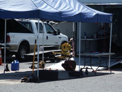 2001 Mercury Grand Marquis - A white pickup truck is parked under a blue canopy, with various tools and equipment scattered around.