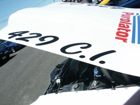 2001 Mercury Grand Marquis - A white car hood displays racing decals and a partial view of the engine bay, with another car in the background.