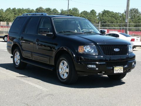 2001 Mercury Grand Marquis - A black Ford Expedition is parked in a lot, with another white car visible in the background.