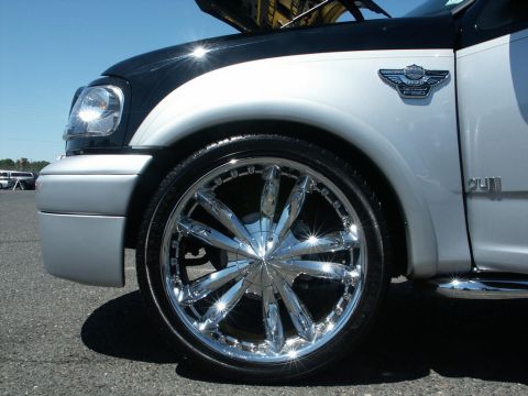 2001 Mercury Grand Marquis - Close-up of a custom truck's front wheel and fender, a Harley-Davidson F-150 emblem.
